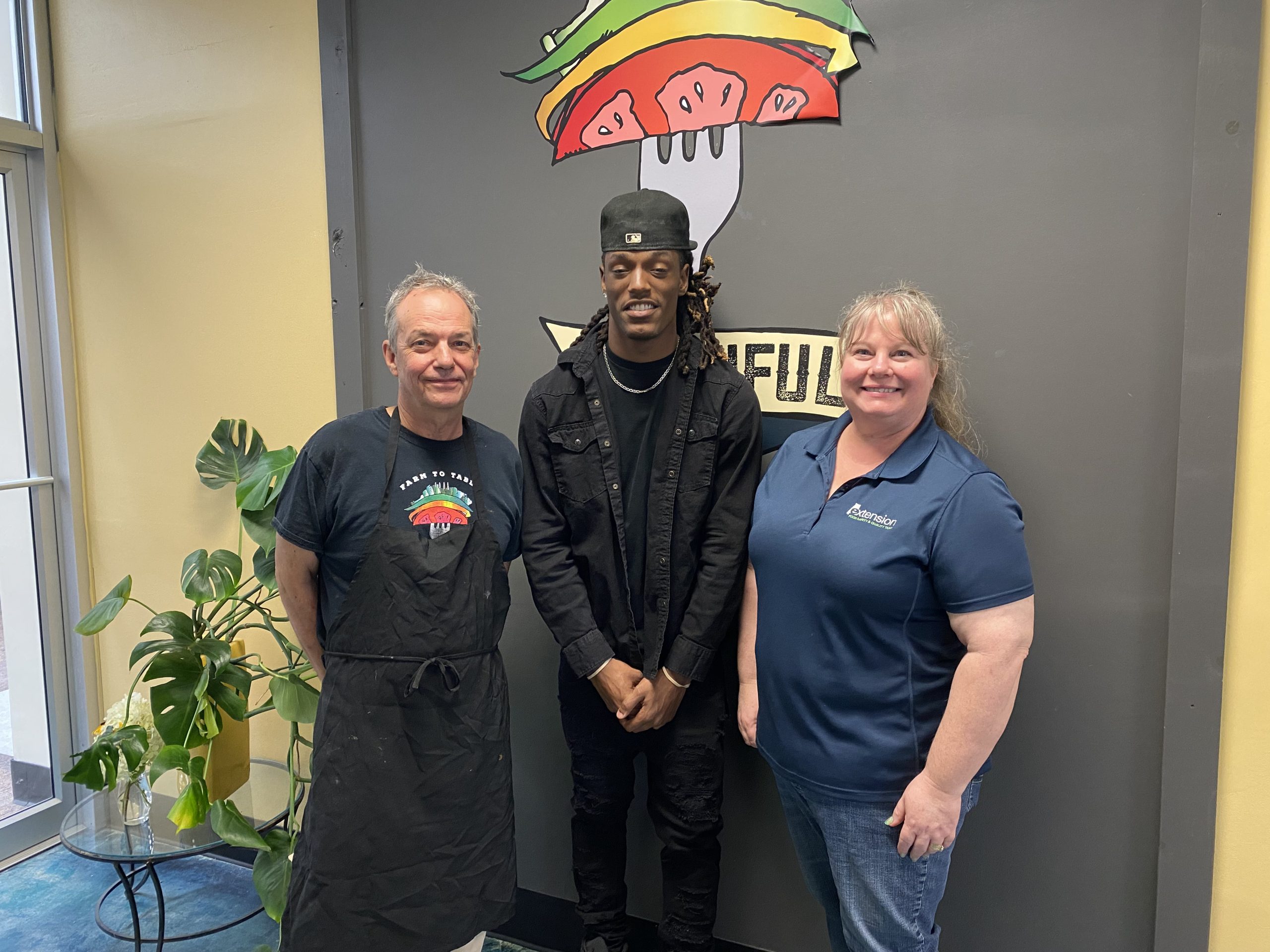 Chip Rowan, Chris Underwood and Christy Mendoza posing for a picture at the Beautiful Rainbow Cafe.