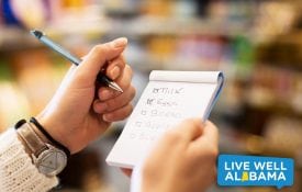 Young Woman with Shopping List at Supermarket