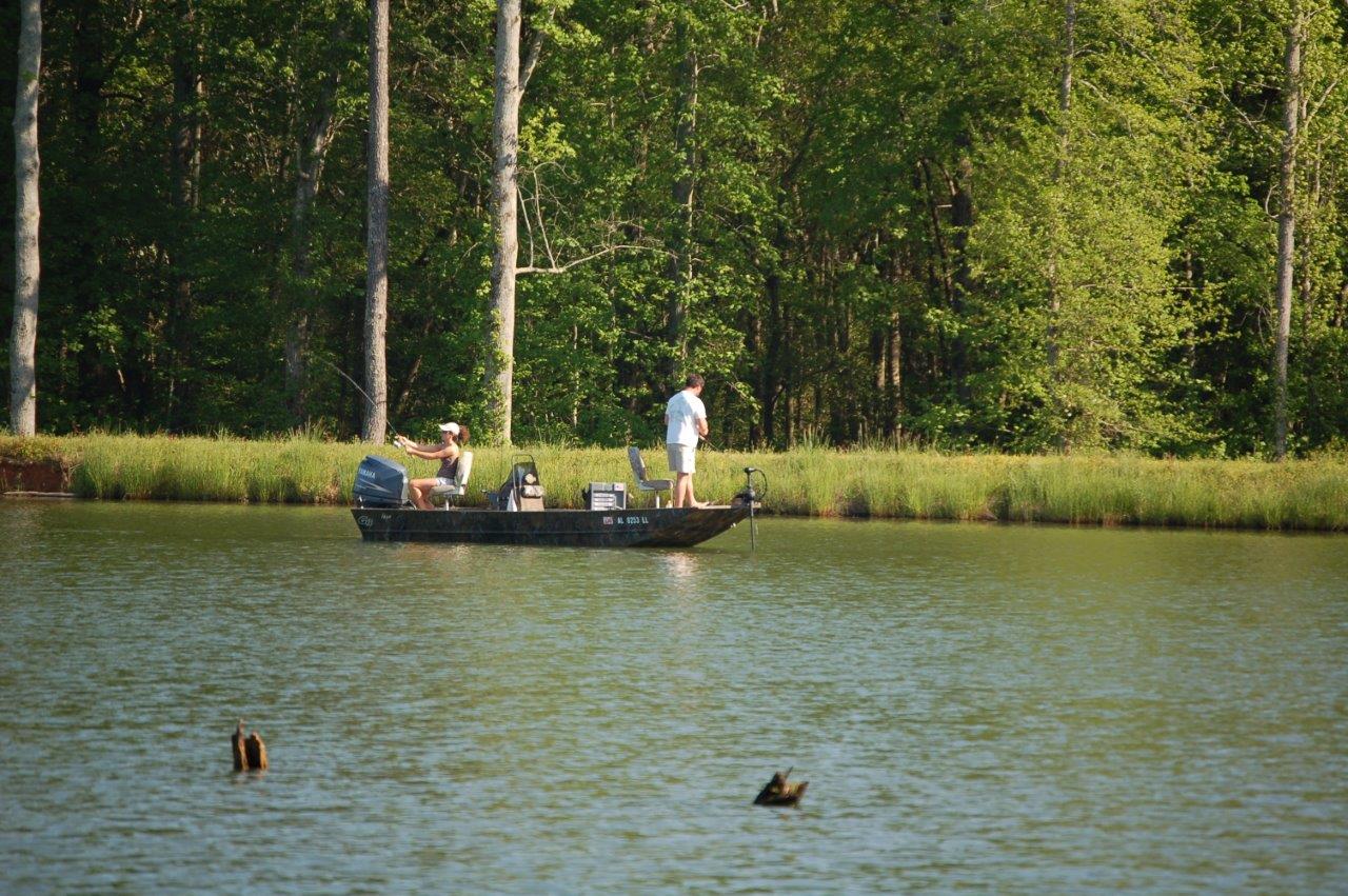 People fishing in a boat on a pond