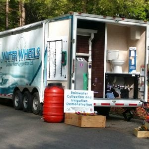Water wheels mobile water conservation laboratory with the back trailer door open, revealing rainwater collection and irrigation demonstration