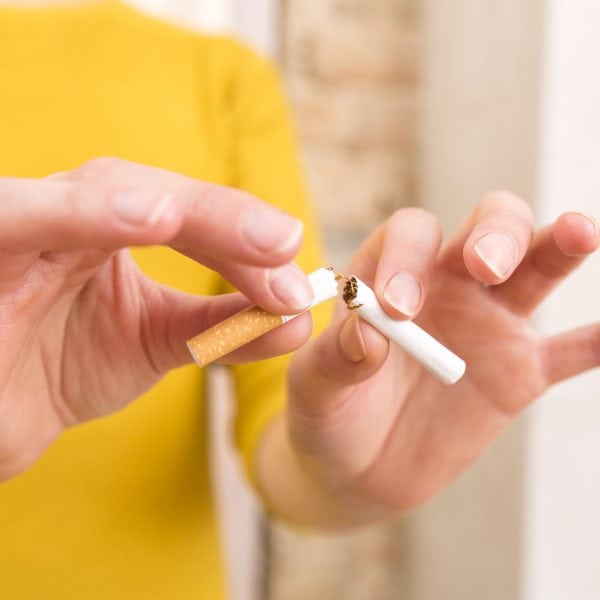 close up of hands breaking a cigarette, quit smoking