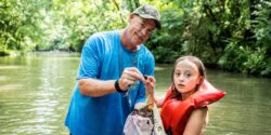 Alabama 4-H volunteer and member in creek during lesson