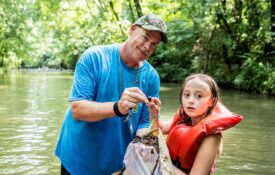 Alabama 4-H volunteer and member in creek during lesson