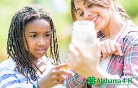 Alabama 4-H volunteer outdoors with 4-H member monitoring water quality