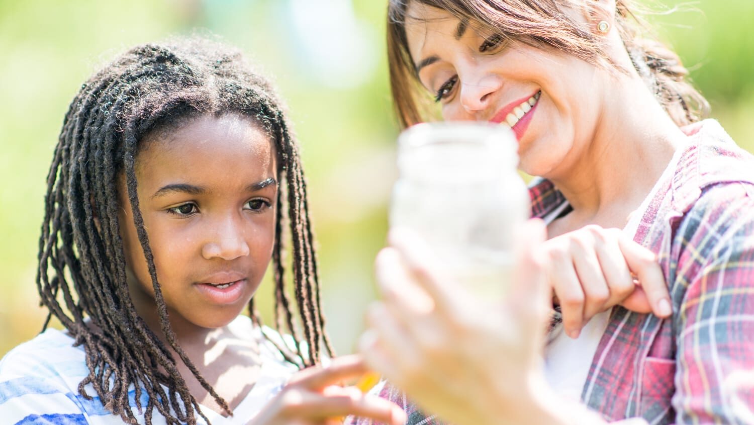 Alabama 4-H volunteer outdoors with 4-H member monitoring water quality