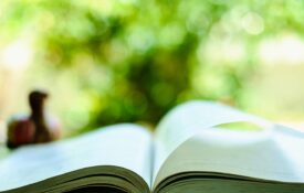 An open book open on a table in an outdoor setting.