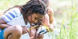 Alabama 4-H Project WILD 4-H member looking through magnifying glass