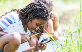 Alabama 4-H Project WILD 4-H member looking through magnifying glass