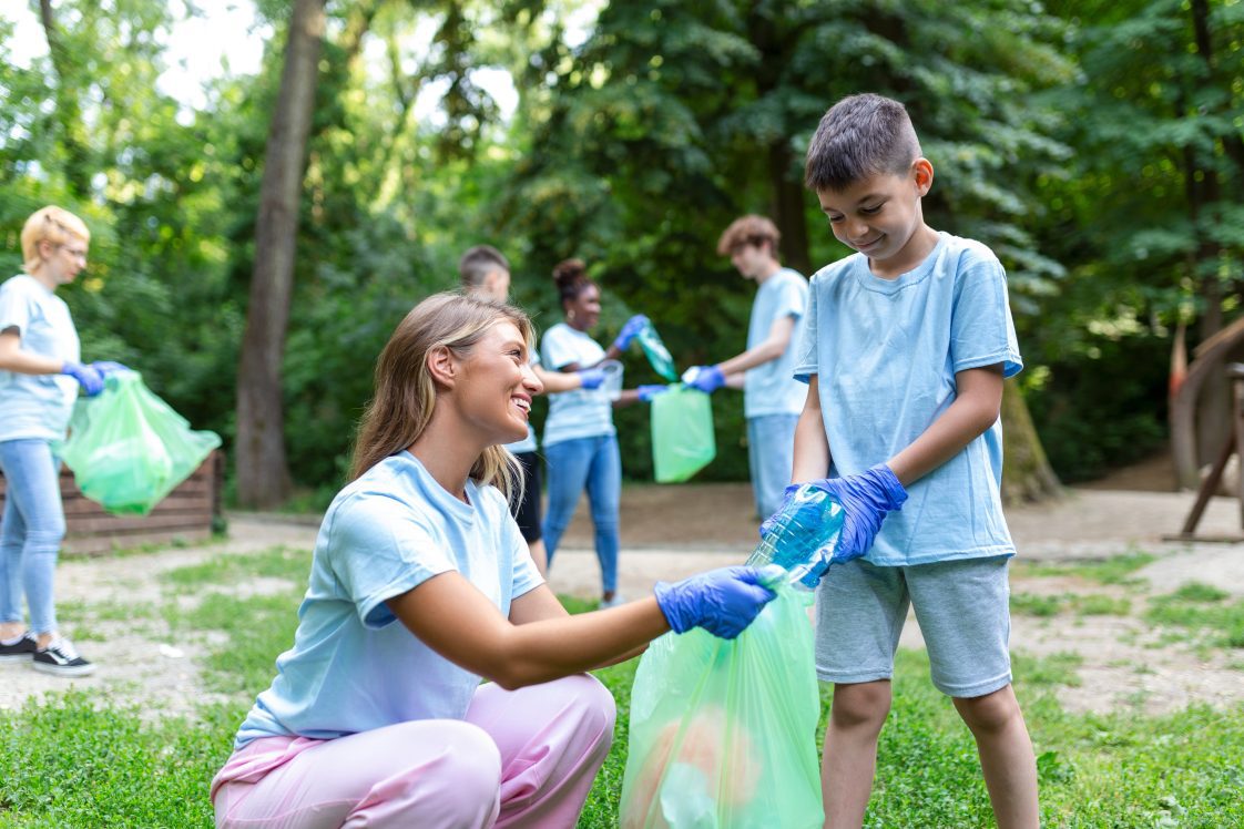A group of kids and adults picking up trash.