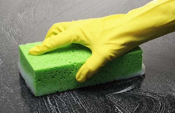 Cleaning a shiny surface with sponge and rubber gloves