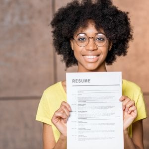 Portrait of a young african woman holding resume document indoors