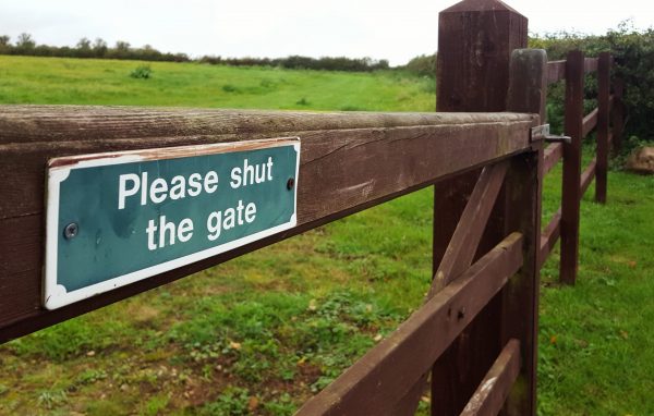 Please shut the gate sign on a wooden fence