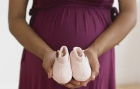 Today's Mom, EFNEP, Pregnant African woman holding baby shoes