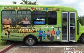The side of the Nutrition Education on the Move Bus parked in a parking lot.