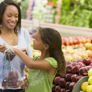 African American mother and daughter in supermarket produce section
