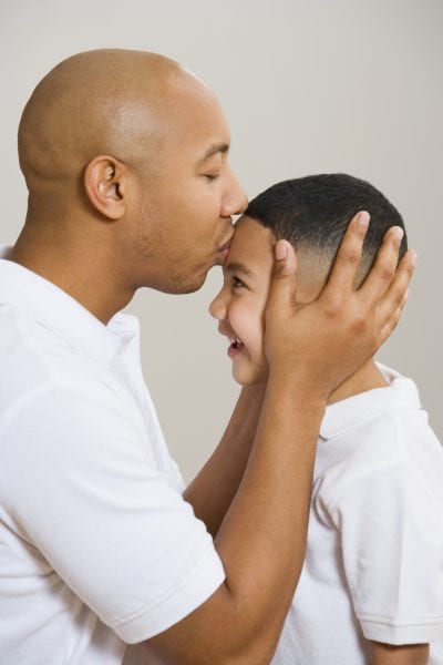 Father kissing son's forehead