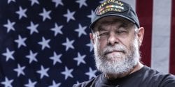 Close-up headshot of an authentic 67 year old United States Navy Vietnam War military veteran looking at the camera.