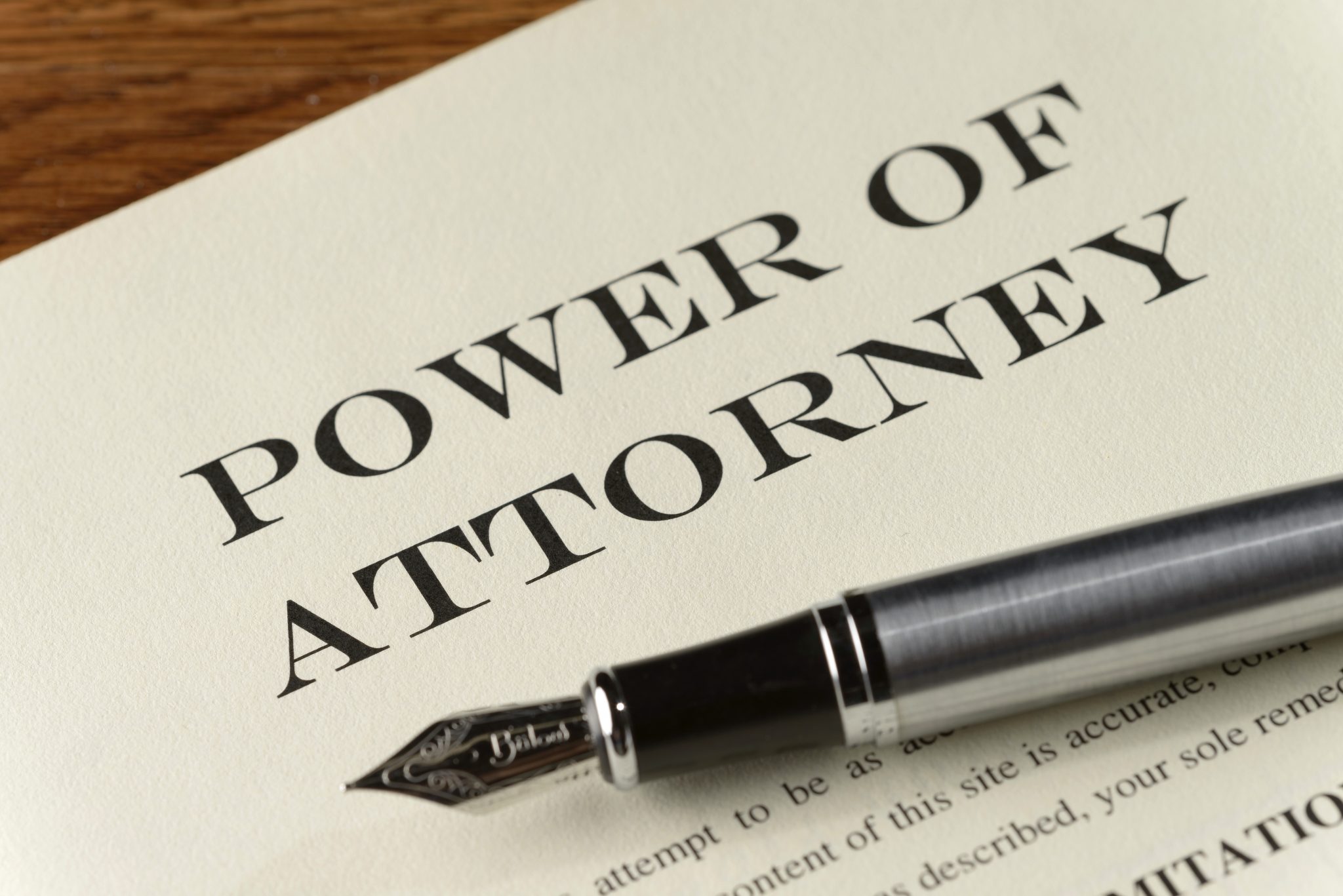 A power of attorney document on a desk with a pen.