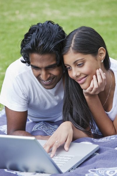 Indian man and woman using laptop computer.
