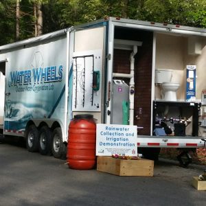 View of the back of the Water Wheels trailer with rainwater collection and irrigation demonstration.
