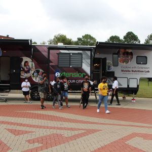 Exterior view of the Mobile Nutrition Lab with people walking about and touring the trailer.