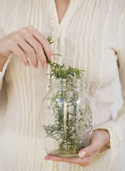 Woman taking herbs out of jar