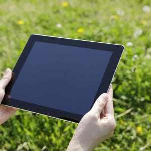 Female using a digital tablet,green leaves background.