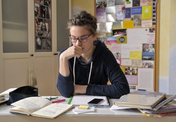 Female teenager sitting at a desk