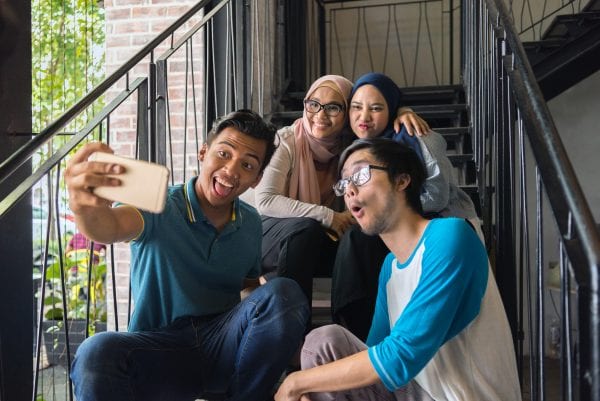 Group of teens talking a group selfie