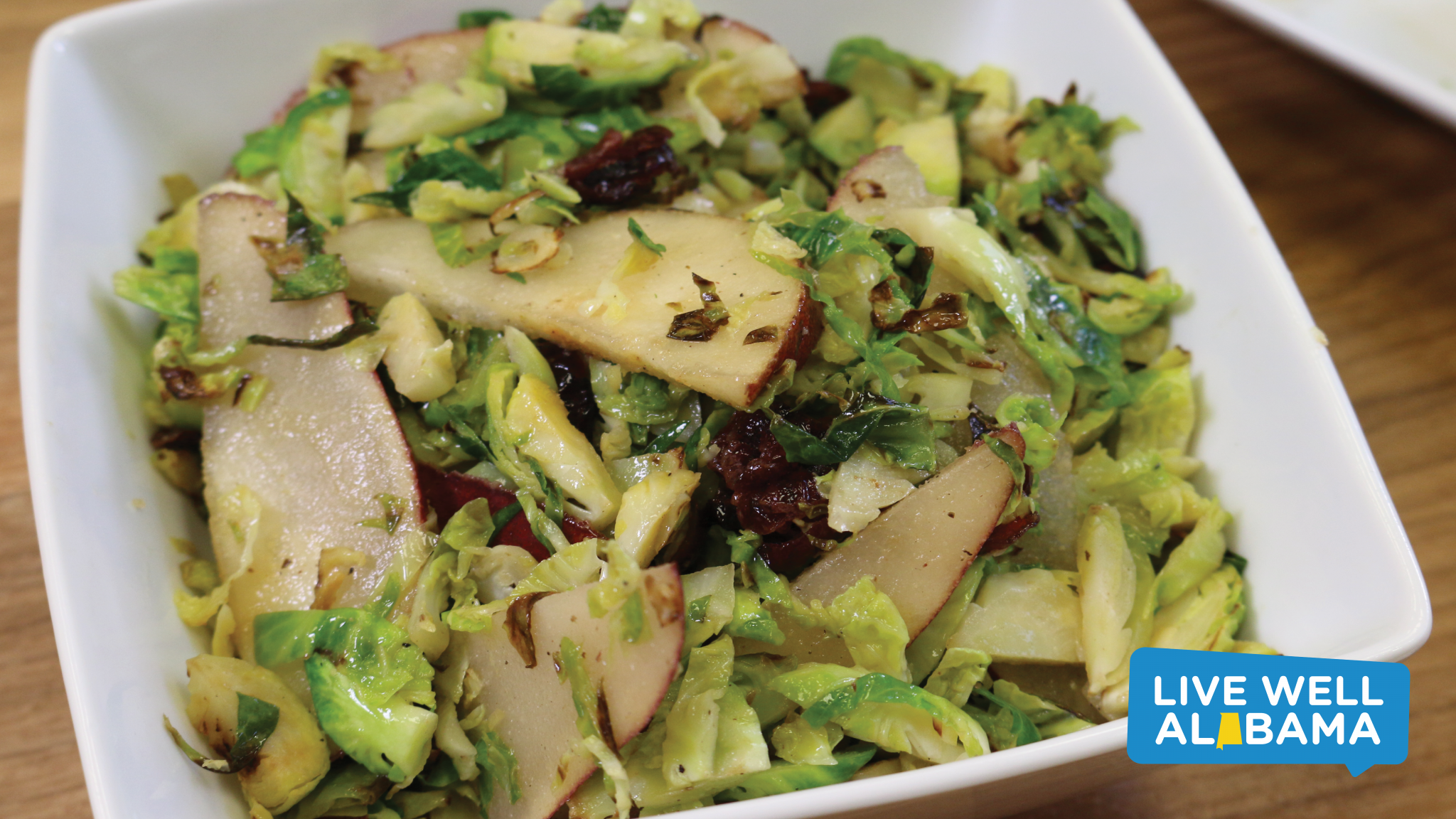 A warm Brussels sprouts and pear salad in a bowl.