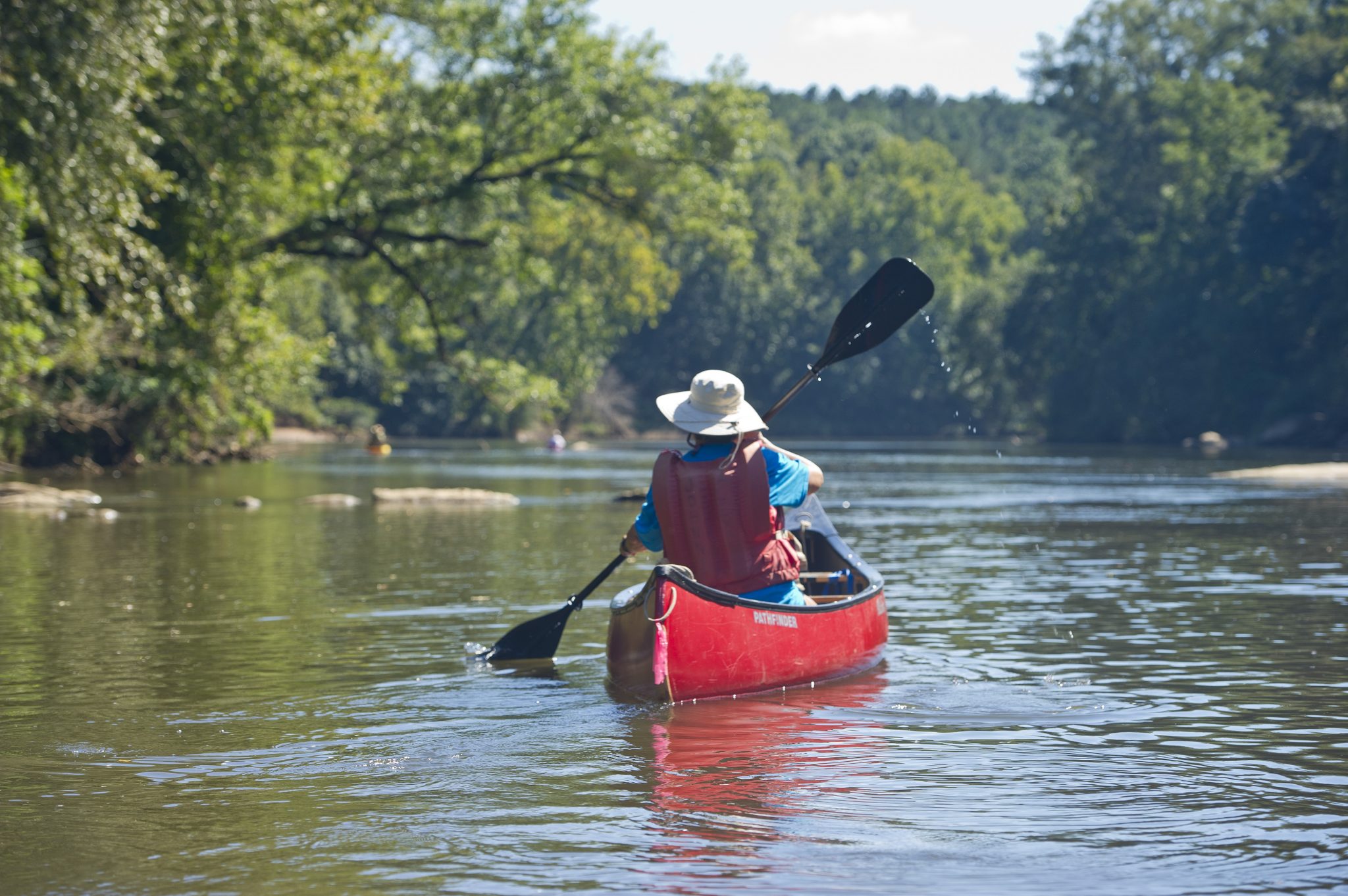 A person canoeing on a river.