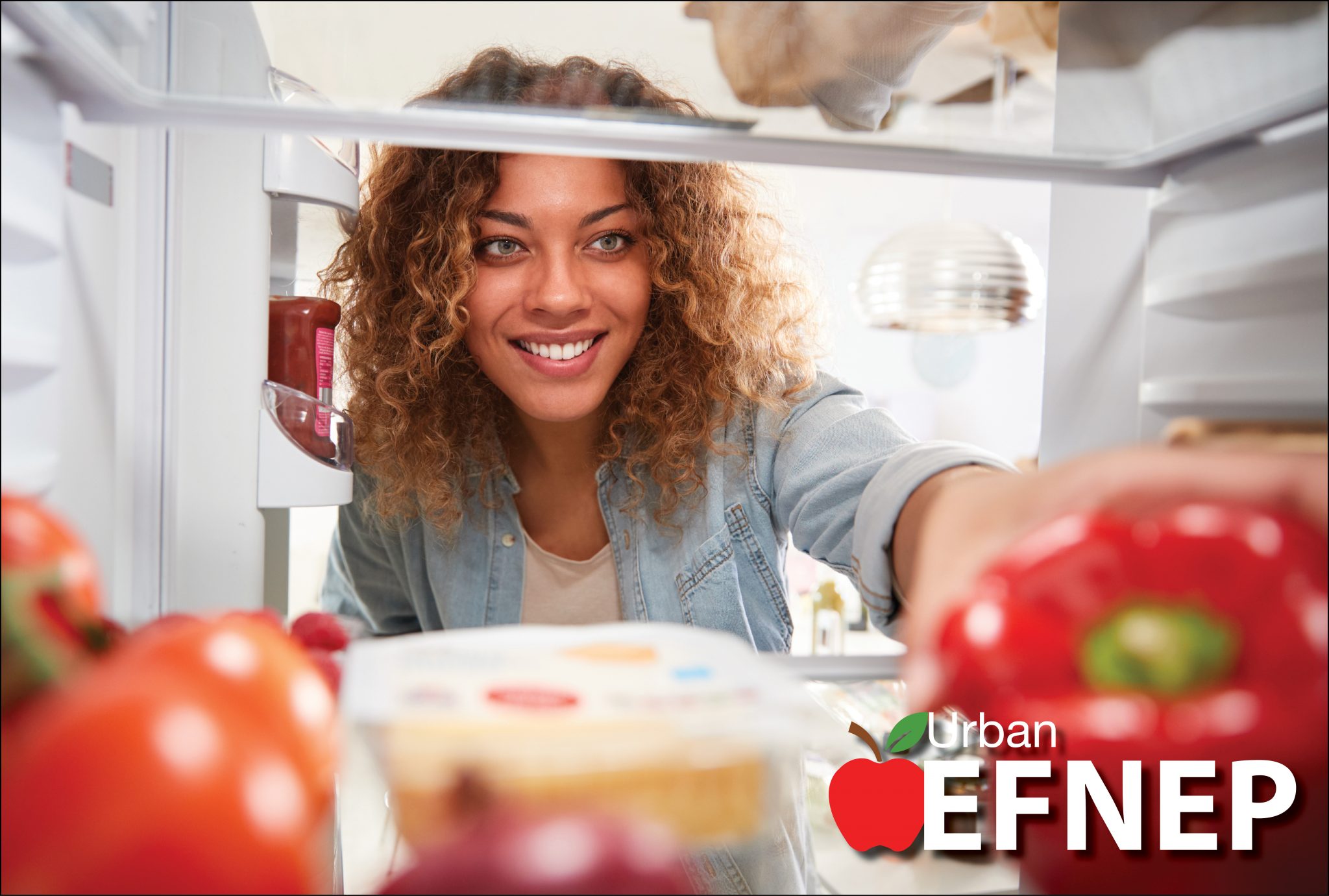 A woman reaching into a refrigerator.