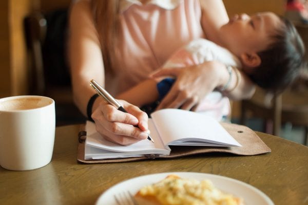 Working mom with her sleeping son on her arm