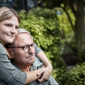 Adult granddaughter embracing grandfather