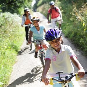 Family cycling on country lane