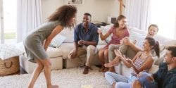 Group Of Friends At Home Having Fun Playing Charades Together