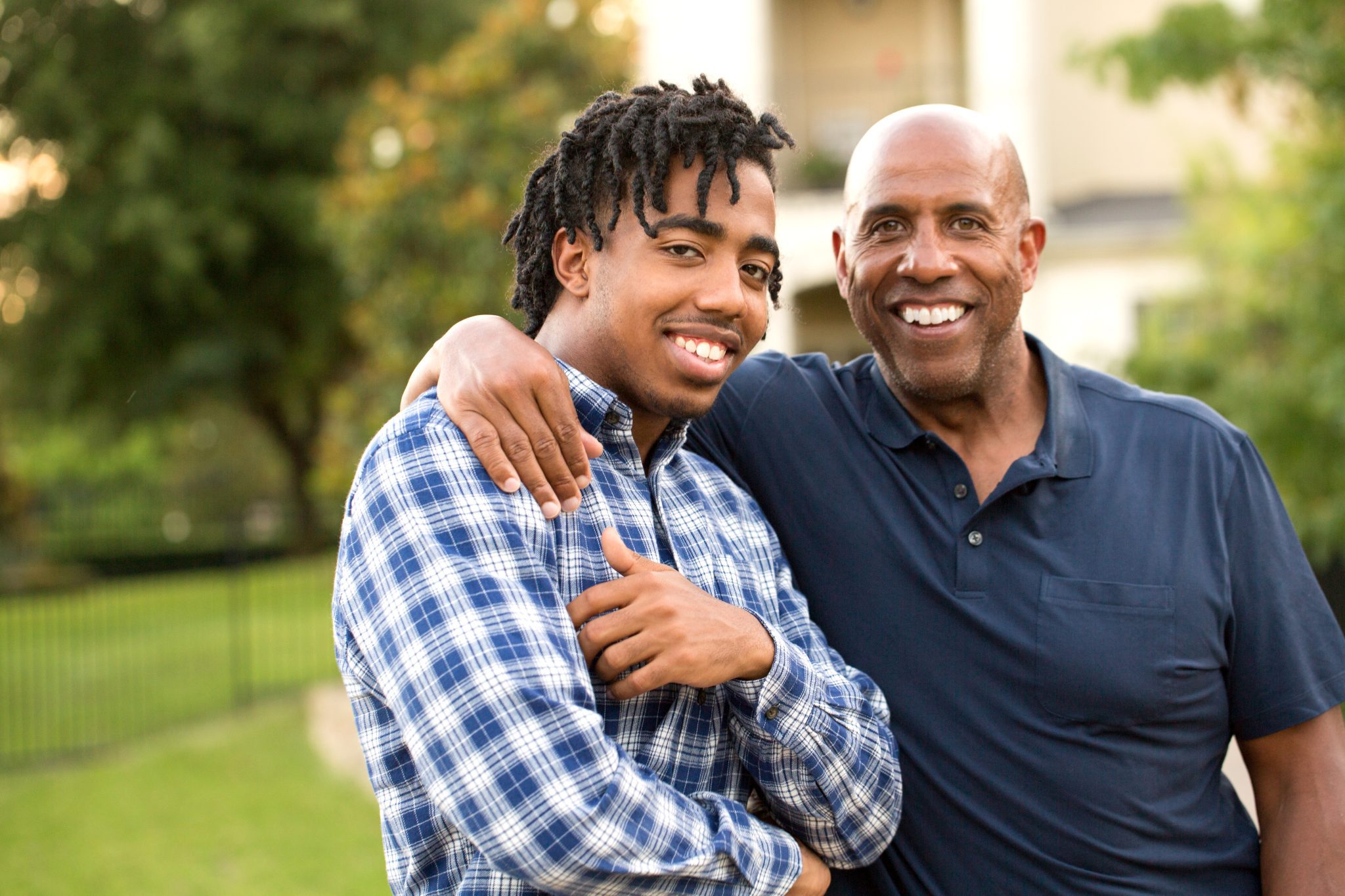 African American father and his adult son talking and laughing.