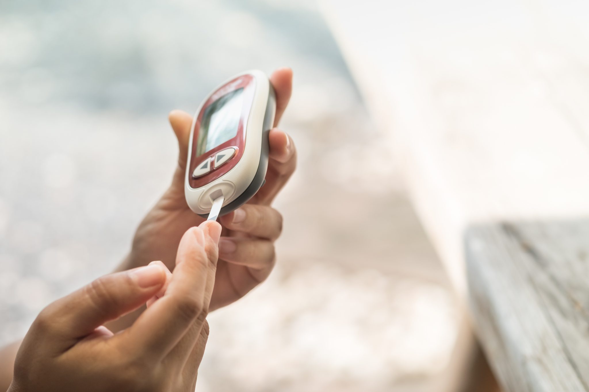A person checking their blood glucose levels with a handheld meter.