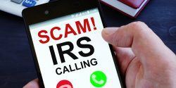 Hand is holding phone with irs scam calls.
