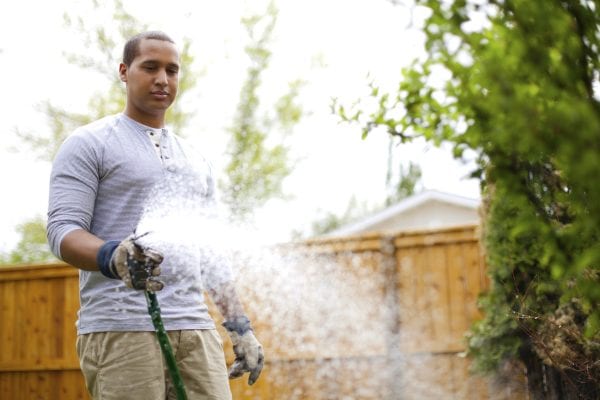 young adult man watering garden