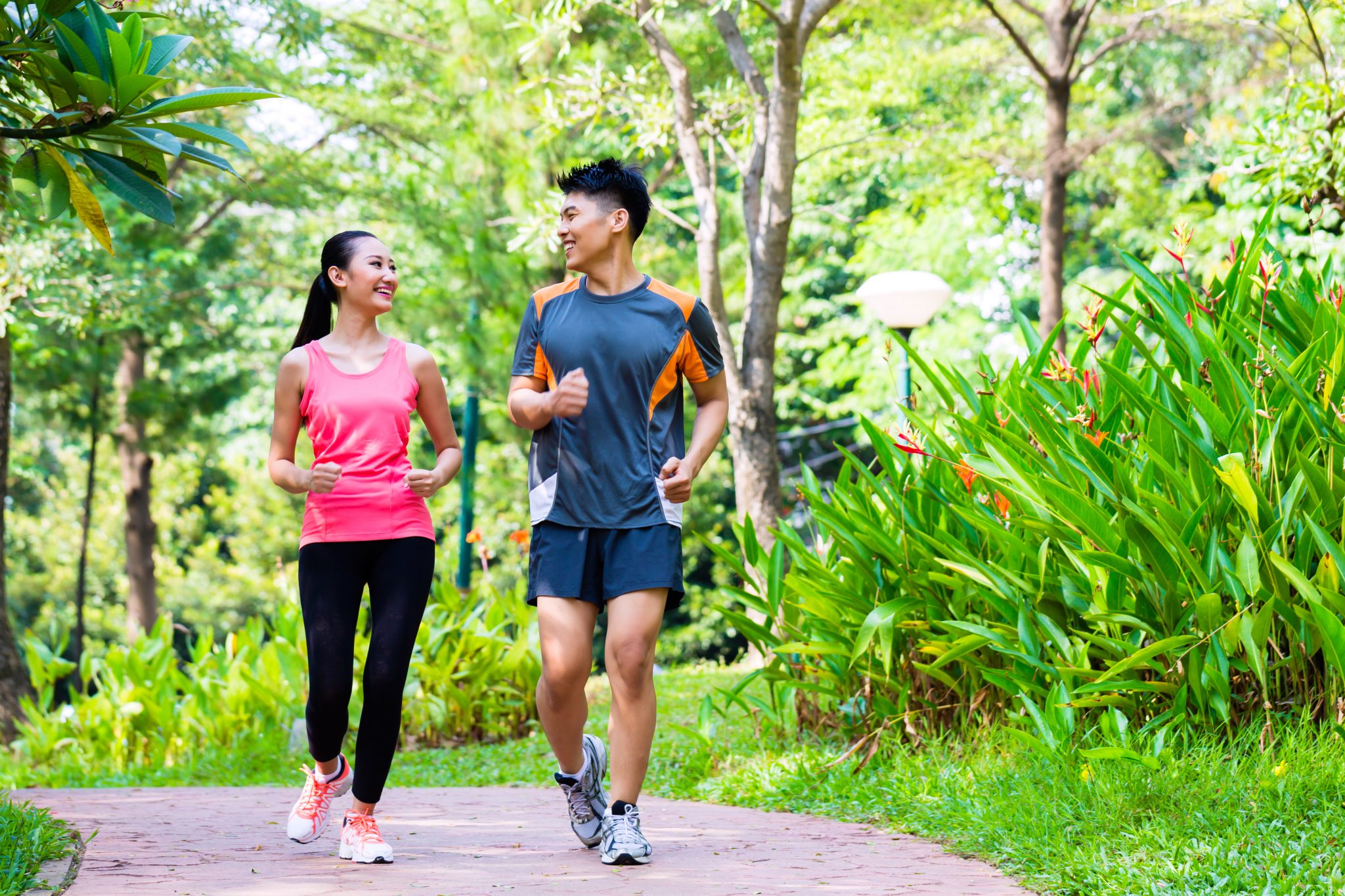 Young Asian couple jogging in a park.