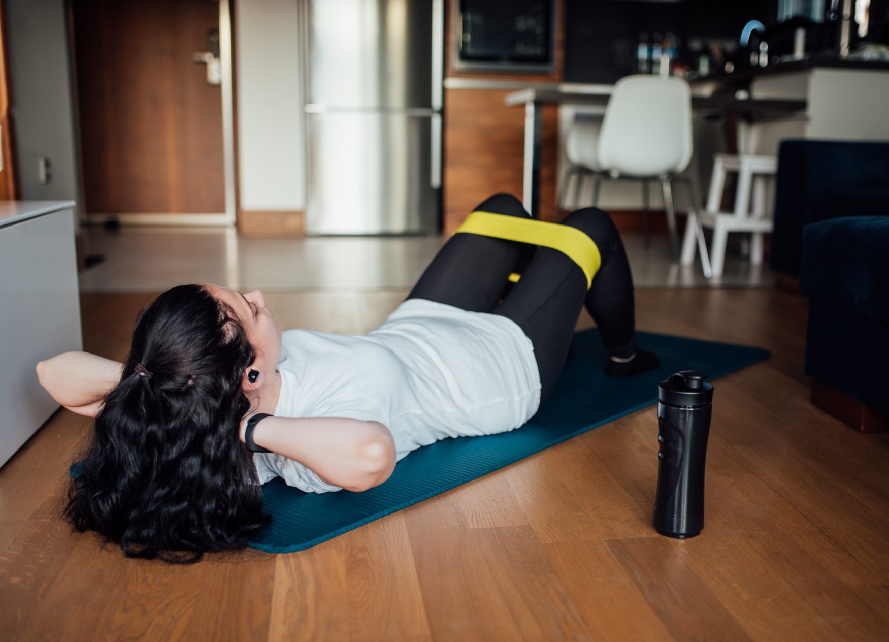 Woman doing exercises with resistance band at home