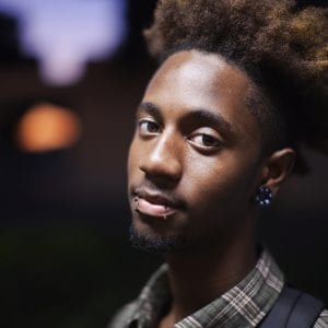 African teenage boy with lip and ear piercings