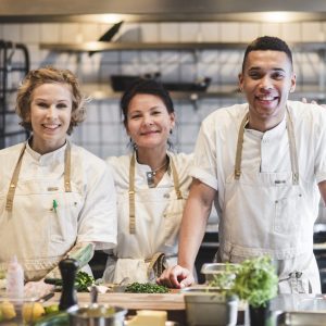 Three chefs in a restaurant kitchen.