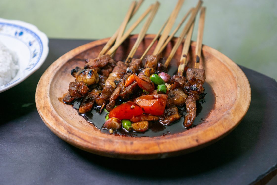 Soy sauce goat satay on a wooden plate