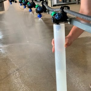 Figure 2. Calibrating a boom sprayer requires catching output from individual nozzles in fluid ounces for the calculated time.