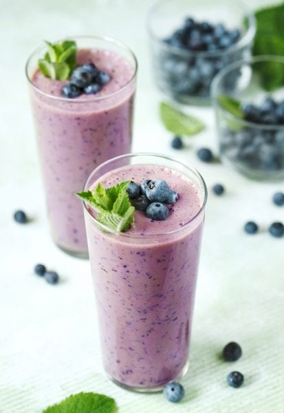 Two Glasses of blueberry milkshake.