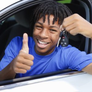 A teenage boy celebrating that he passed his driver's test.
