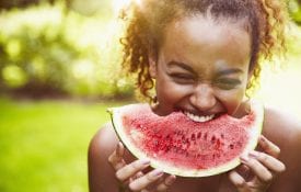 A young woman eating watermelon