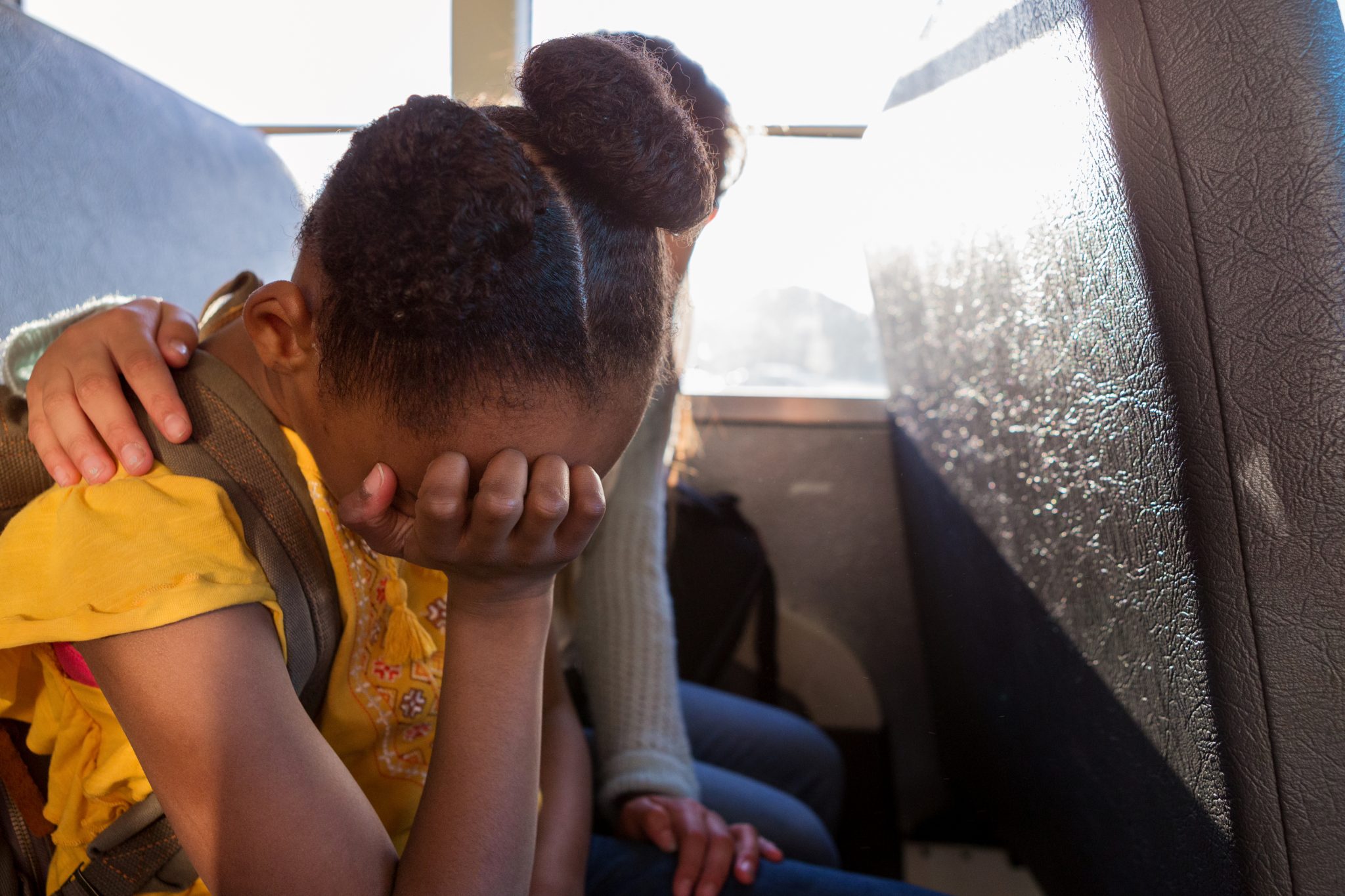 A young girl crying on a bus